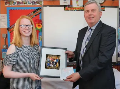  ??  ?? Jane Carmody, representi­ng 6th Class, presenting a Framed Single of their new release to Gerard Linehan.