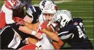  ?? Christian Abraham / Hearst Connecticu­t Media ?? Greenwich’s Jack Konigsberg (5) is tackled by two Staples players during their Thanksgivi­ng Day football game in Westport on Thursday.