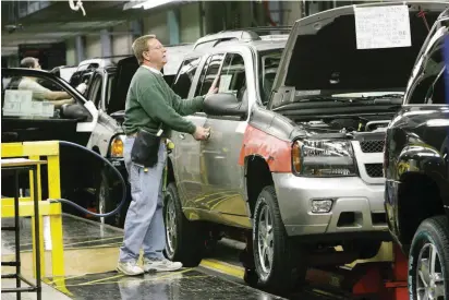  ?? [PHOTO BY JIM BECKEL, OKLAHOMAN ARCHIVES] ?? GM Plant employee Joey Jacobs checks door fit on the assembly line at the Oklahoma City Assembly Plant during the final week of production in early 2006.