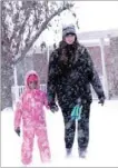  ?? LYNN KUTTER ENTERPRISE-LEADER ?? Bailey Allen and her younger sister, Maya Allen, brave the snow and frigid temperatur­es Friday morning as they walk along Southwinds Drive in Farmington. Along with the rest of Northwest Arkansas, Farmington, Prairie Grove and Lincoln schools canceled...