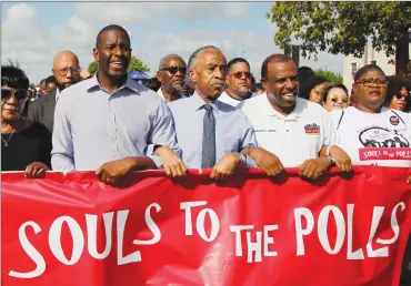  ?? Associated Press photo ?? Florida Democratic gubernator­ial candidate Andrew Gillum, centre, marches to the Caleb Center arm-locked with Al Sharpton, and local politician­s and supporters, as part of the “Souls to the Polls” event Sunday.