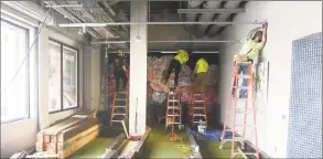  ?? Tyler Sizemore / Hearst Connecticu­t Media ?? Constructi­on crews complete the bocce courts inside the new Pinstripes bistro, bowling, and bocce lounge at the SoNo Collection shopping center on Wednesday.