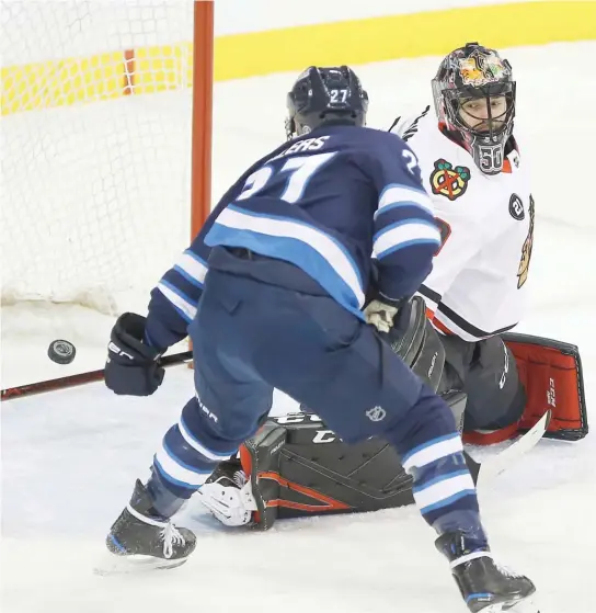  ?? JOHN WOODS/AP ?? Jets forward Nikolaj Ehlers, who had a hat trick, beats Blackhawks goaltender Corey Crawford in the first period Thursday night at Bell MTS Place.