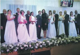  ??  ?? Las seis parejas que contrajero­n nupcias en la boda masiva, posaron junto a los pastores.