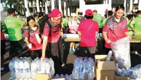  ??  ?? HSL staff members distribute drinking water to the runners.