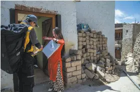  ?? Atul Loke / New York Times ?? Eshay Rangdol, a courier with Incredible Himalaya, a local partner of Amazon, delivers a package to Skalzing Dolma in the mountain town of Leh, India.