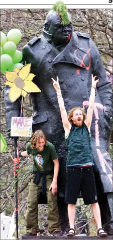  ?? ?? DEFACED: Protesters on the graffiti covered statue of Winston Churchill in Parliament Square