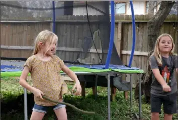  ?? Francois Picard/AFP via Getty Images ?? Sunny Bryant, left, plays with her brother, Bodhi, in the backyard of their Houston, Texas, home on March 4. Rebekah Bryant is outraged after the state of Texas ruled hormone treatments she might give her transgende­r daughter, Sunny, 8, when she reaches adolescenc­e are illegal.