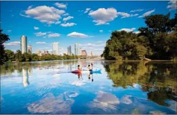  ?? AUSTIN CONVENTION & VISITORS BUREAU VIA THE WASHINGTON POST ?? Kayakers take in the skyline from Lady Bird Lake, which is encircled by a hiking-and-biking trail that stretches more than 16 kilometres.