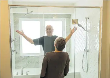  ?? BRANDON HARDER ?? Grand prize winners Garth Robson and his partner Bev Crossman explore the home they won. Robson likes his new shower, and his gesture draws a laugh from Crossman.