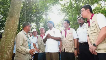  ??  ?? Going green:Dr Xavier (centre) being briefed by Forest Research Institute Malaysia officer Dr Ang Lai Hoe (left) at the Paya Indah Wetlands. Also present are Washizawa (third from right) and Aeon executive director Poh Ying Loo (right).