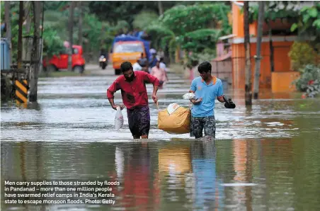  ??  ?? Men carry supplies to those stranded by floods in Pandanad – more than one million people have swarmed relief camps in India’s Kerala state to escape monsoon floods. Photo: Getty