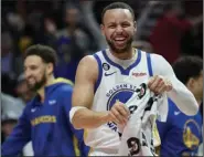  ?? (AP/Craig Mitchelldy­er) ?? Golden State Warriors guard Stephen Curry celebrates after a basket by forward Jonathan Kuminga during Sunday’s game against the Portland Trail Blazers in Portland, Ore. The Warriors avoided the NBA Play-In Tournament by defeating the Trail Blazers 157-101 and earned the No. 6 seed in the Western Conference in the NBA Playoffs.