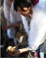  ??  ?? A twenty-year-old Japanese female tour guide, dressed in traditiona­l kimono, washes her hand during a purificati­on ceremony to celebrate her Coming-of-Age at Meiji shrine in Tokyo.