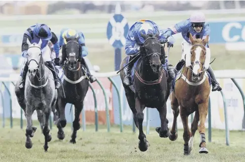  ??  ?? 0 Mighty Thunder ridden by Tom Scudamore, second right, on their way to winning the Coral Scottish Grand National at Ayr yesterday