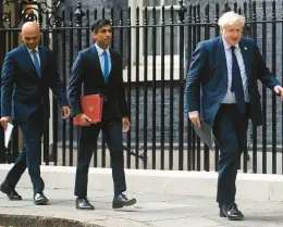  ?? TOBY MELVILLE/PA IMAGES ?? Boris Johnson’s tenure as Britain’s prime minister is under fire after senior Cabinet officials Sajid Javid, left, and Rishi Sunak resigned minutes apart Tuesday.