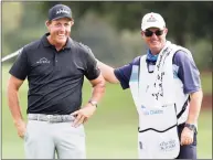  ?? Joe Mahoney / Associated Press ?? Winner Phil Mickelson gets a pat on the back from Jeff Johnson, the caddie for Retief Goosen, during final-round play in the Dominion Energy Charity Classic at the Country Club of Virginia in Richmond, Va., on Sunday. Mickelson finished 3 strokes ahead of Mike Weir.