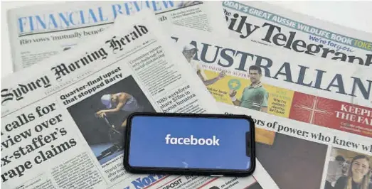  ?? Lukas Coch / EFE ?? Un mòbil amb el logo de Facebook destaca davant la capçalera de diversos diaris australian­s.