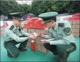  ?? LIAO JIAN / FOR CHINA DAILY ?? Border police officers in Xiamen, Fujian province, inspect counterfei­t cigarettes on Monday. The officers stopped a truck loaded with more than 23,000 cartons of the cigarettes with an estimated street value of 3.5 million yuan ($528,000).