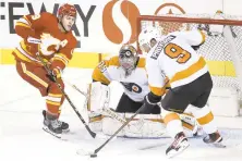  ?? LARRY MACDOUGAL/AP ?? The Flyers’ Ivan Provorov, right, battles for the puck with Calgary’s Matthew Tkachuk, in front of Flyers goalie Carter Hart during the second period of Saturday’s game in Calgary, Alberta.