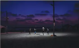  ?? (AP/Oded Balilty) ?? Israelis play under a light pole June 26 on Tel Aviv’s beach.