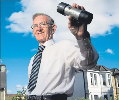  ??  ?? Former fireman John Jamieson with the automatic distress signal device he invented nearly 40 years ago