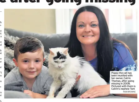  ?? ROB BROWNE ?? Poppy the cat has been reunited with her owner, Catrin Thomas, after going missing in 2008. Pictured with them is Catrin’s nephew Tom