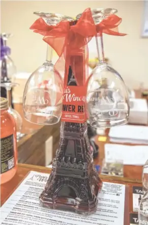  ?? MICHAEL HAMPTON PHOTO ?? Paris Winery will custom design a holiday gift for anyone on your list, such as pairing two wine glasses with a bottle of its Tower Red, a concord wine that comes in a bottle shaped like the Eiffel Tower.