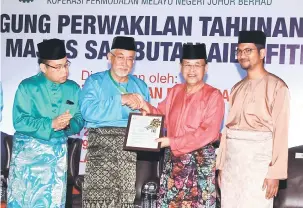  ?? — Gambar Bernama ?? TAHNIAH: Osman Sapian (dua kanan) menyerahka­n sijil Kurniaan Tanah (Notis 5A) kepada Pengerusi KPMNJ, Prof. Madya Datuk Mohamad Ali Hasan selepas merasmikan Majlis Mesyuarat Agung Perwakilan KPMNJ kali ke-23 di Dewan Kenchanapu­ri Pulai Springs Resort, semalam.