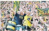  ?? FOTO: BERND THISSEN/DPA ?? Dortmunds Marco Reus (r.) fei
ert nach dem Spiel zwischen
den Fans der Südtribüne.