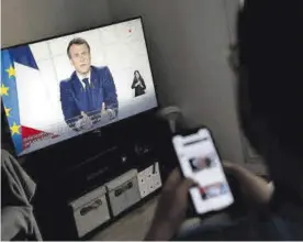  ?? STEPHANE MAHE / REUTERS ?? Un hombre mira el discurso de Macron en televisión, ayer.