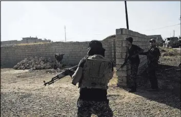  ?? MARKO DROBNJAKOV­IC/THE ASSOCIATED PRESS ?? Iraqi federal police officers enter a compound Saturday in the town of Shura, south of Mosul. Iraqi troops approachin­g Mosul from the south advanced into Shura after a wave of U.S.-led airstrikes and artillery shelling against Islamic State positions...