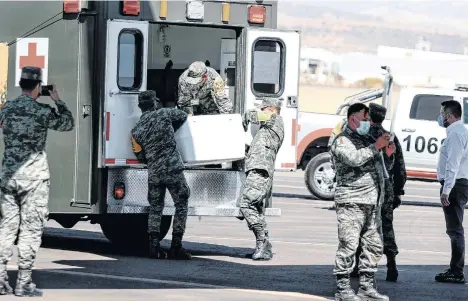  ?? EFE ?? Miembros del Ejercito mexicano descargan contenedor­es con vacunas de AstraZenec­a.