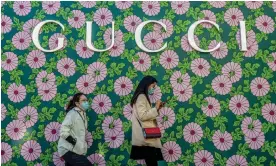  ?? Photograph: Nicolas Asfouri/AFP/Getty Images ?? People walk past a Gucci shop in Beijing, China.