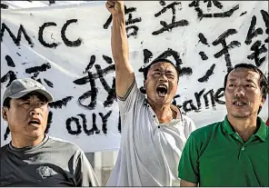  ?? AP/DANIEL LIN ?? Chinese laborers Jingbao Zhao, left, Xiaoli Wang, center, and Yongbo Sun protest in late July in front of the Imperial Pacific Casino in Saipan, the Northern Mariana Islands, a U.S. commonweal­th in the Western Pacific.