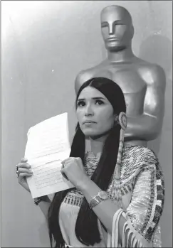 ?? THE ASSOCIATED PRESS, FILE ?? Sacheen Littlefeat­her, a Native American activist, tells the audience at the Academy Awards ceremony in Los Angeles, March 27, 1973, that Marlon Brando was declining to accept his Oscar as best actor for his role in “The Godfather.”