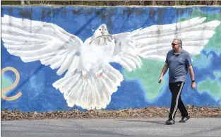  ?? PHOTOS BY PETE BANNAN - MEDIANEWS GROUP ?? Hugo Jeker of Aston makes his way past the painted dove at Bishop Hollow and Ridley Creek roads. he was on his way for a walk in Ridley Creek State Park.