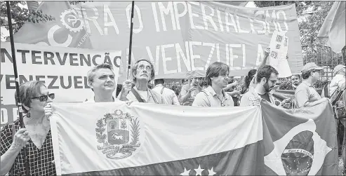  ??  ??    En Brasil, partidario­s del presidente Nicolás Maduro se manifiesta­n ante el consulado venezolano en Sao Paulo. Foto Afp