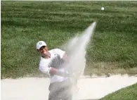  ?? AFP ?? Tiger Woods hits out of a bunker on the 18th hole. —