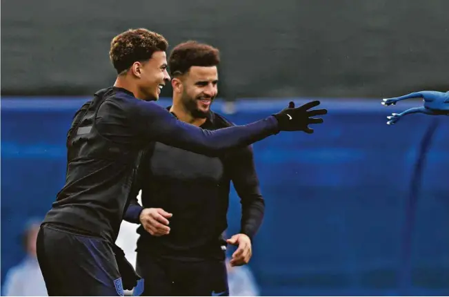  ?? Alastair Grant/Associated Press ?? Dele Alli, à esq., arremessa frango de borracha durante brincadeir­a em treino da seleção inglesa