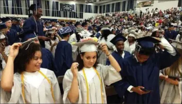  ?? RICHARD PAYERCHIN — THE MORNING JOURNAL ?? Lorain High School graduating seniors received their diplomas during the 2018 Lorain High School commenceme­nt held June 5, 2018, at the high school, and here get ready to switch their tassel to signify their new status as Lorain Titan alumni. The Lorain City School district has announced the 2019 commenceme­nt will take place at the Wolstein Center in Cleveland.