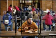  ?? CHARLIE RIEDEL — ASSOCIATED PRESS ?? In this March 31, 2021, file photo, freshman Hugo Bautista eats lunch separated from classmates by plastic dividers at Wyandotte County High School in Kansas City, Kan., on the first day of in-person learning.