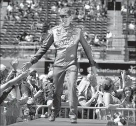  ?? Ralph Freso Associated Press ?? KYLE BUSCH, greeted by fans before winning his 199th NASCAR race last weekend in Arizona, will go for the milestone Sunday at Auto Club Speedway.