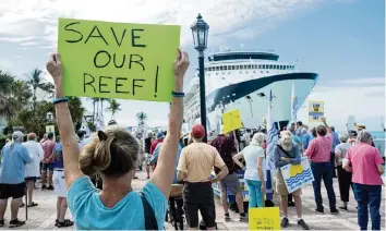  ?? MARK HEDDEN For the Miami Herald ?? Protesters with the Key West Committee for Safer Cleaner Ships on Feb. 5. with a giant ship in the background.