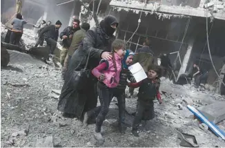  ?? ABDULMONAM EASSA AGENCE FRANCE-PRESSE ?? Une femme et des enfants syriens courent se mettre à l’abri des bombardeme­nts de l’armée syrienne sur la ville rebelle de Hamouria, en Ghouta orientale.