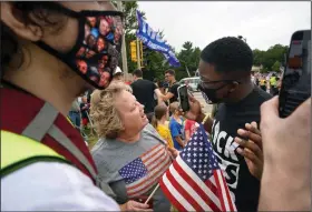  ?? (The New York Times/Chang W. Lee) ?? A supporter of President Donald Trump (left) argues with a Black Lives Matter protester Tuesday as Trump arrives in Kenosha, Wis. A large police presence, including several armored vehicles, secured the area.