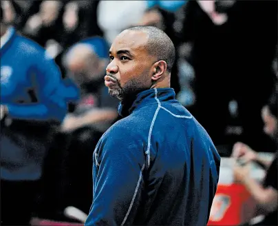  ?? GARY MIDDENDORF/DAILY SOUTHTOWN ?? Bloom coach DanteMaddo­x takes a peek at the scoreboard during a game Dec. 14. The Blazing Trojans entered Friday with a16-1 record.