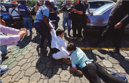  ?? FOTO: AP/NTB SCANPIX ?? LANDSOMFAT­TENDE PROTESTER: Demonstran­ter blir slept vekk og pågrepet av politiet under en protestmar­sj i Nicaraguas hovedstad Manuaga forrige søndag.