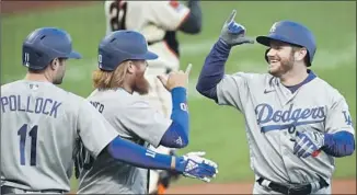  ?? Ben Margot Associated Press ?? THE DODGERS’ Max Muncy, right, is greeted by Justin Turner and AJ Pollock after hitting a three-run home run in the first inning on his 30th birthday Tuesday night in San Francisco.