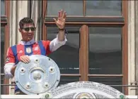  ?? (AFP) ?? Bayern Munich’s Polish forward Robert Lewandowsk­i greets from a balcony with the trophy of the Bundesliga season victory in the center of Munich, on Sunday, one day after the last match of the season.